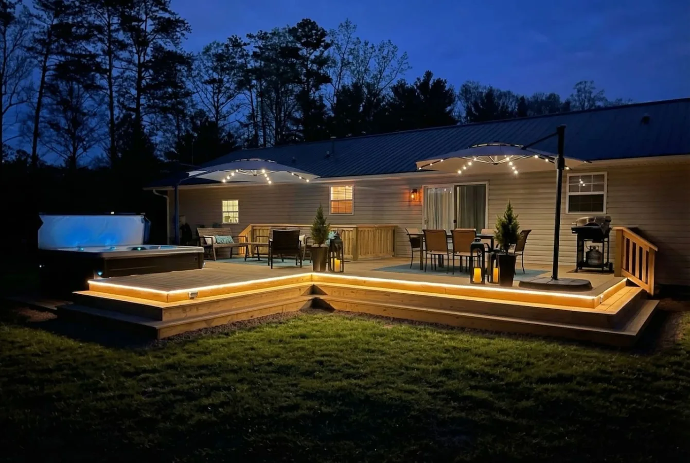 A Leisr Stays managed deck with a hot tub lit up at twilight near Arden, North Carolina