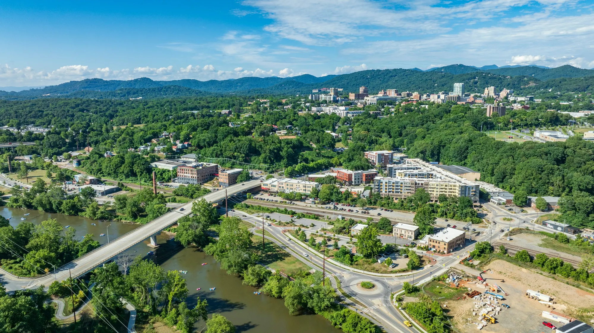 An aerial view of downtown Asheville with the Blue Ridge Mountains behind it