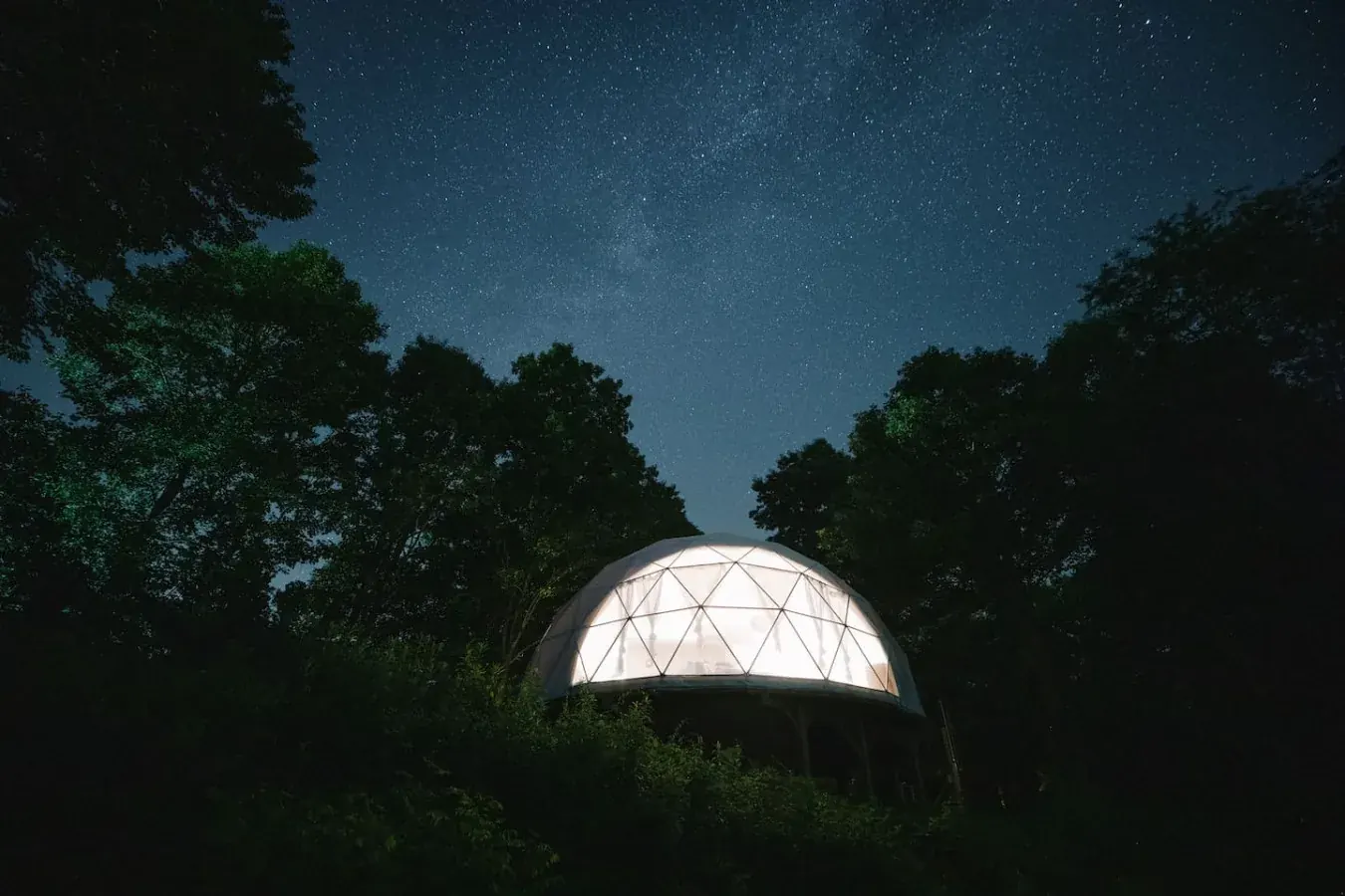 Illuminated dome vacation rental glowing under a starry night sky near Madison Heights, Virginia