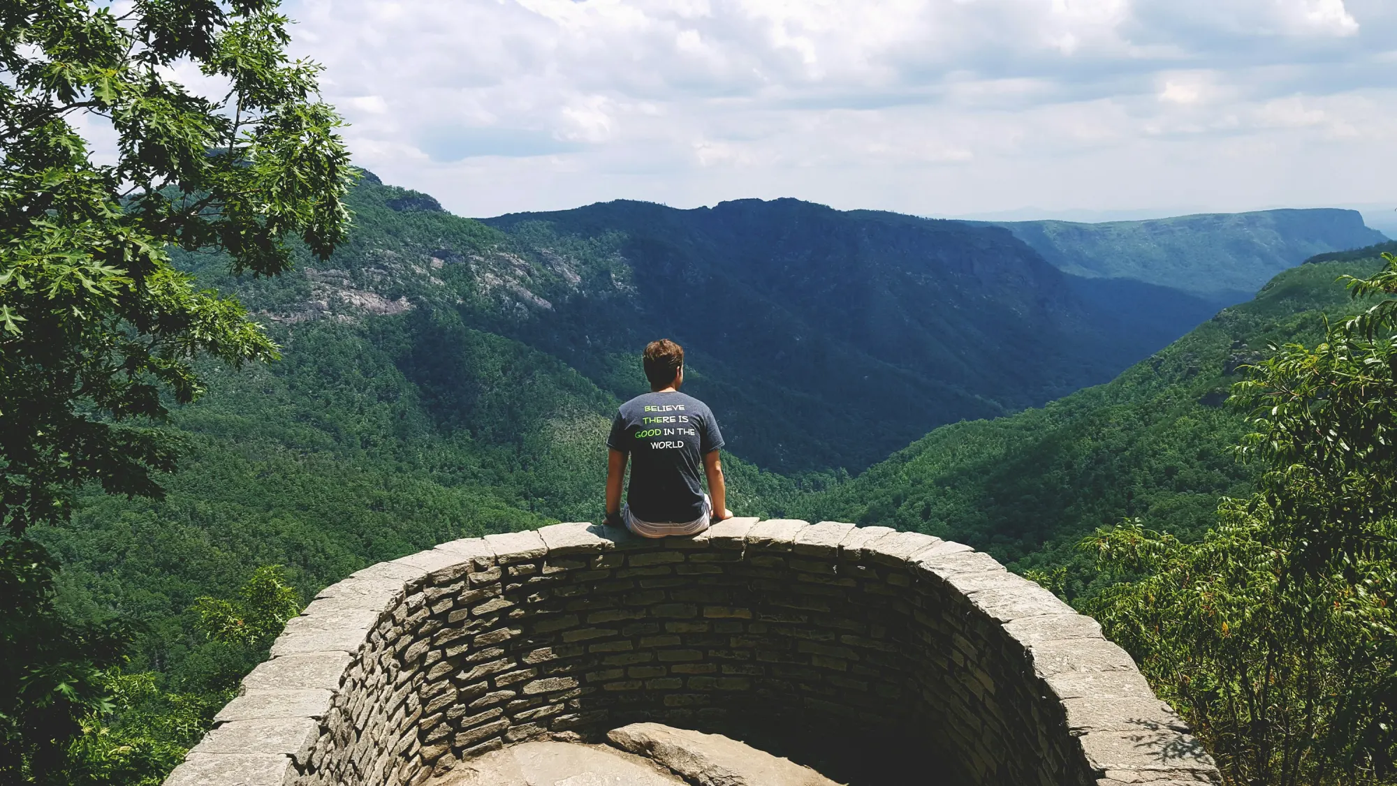 A hiker looks out over the mountains from a stone overlook near Marion, North Carolina